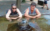 Vorstandsmitglied Martina Gadola, Azmoos (links), und Präsidentin Sonya van Schie-John, Heiligkreuz, vom Kneippverein Sarganserland demonstrieren ein kaltes Armbad im Brunnen beim Buchser Rathauspärkli. (Bild: Hanspeter Thurnherr)